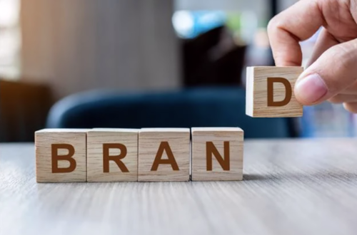 Close-up of wooden blocks spelling ‘BRAND’ being completed, representing strategic development, identity, and business growth.